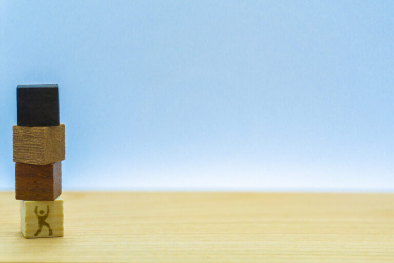 左端に積み上げた木を持ち上げる一生懸命な男の人の努力しているイメージ素材