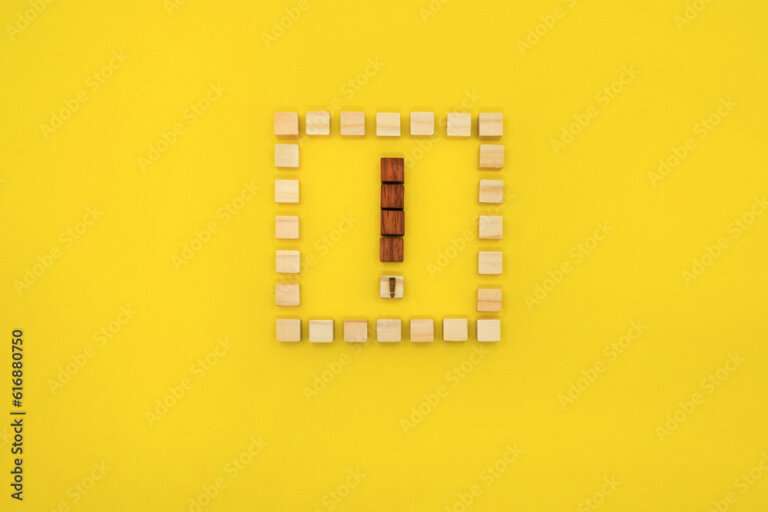 四角いウッドキューブのフレームに赤いビックリマークが入った黄色い背景の正面