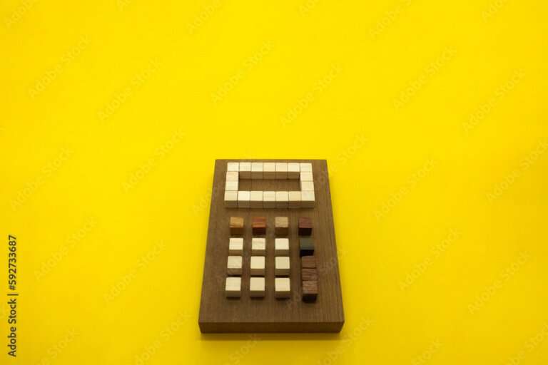 黄色い背景の上に木の素材で形を作った天然の電卓