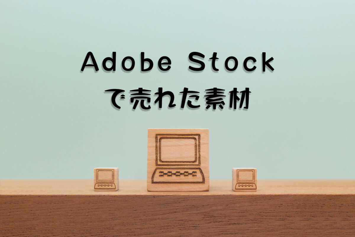 Adobe Stockで売れた122枚目の写真は「机の上で小さいウッドキューブのパソコンに挟まれたパソコンの正面」