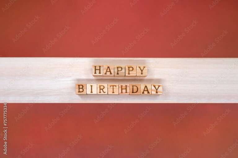 赤い背景にハッピーバースデイの英語のブロックが並ぶ白い木目の誕生日のテープ